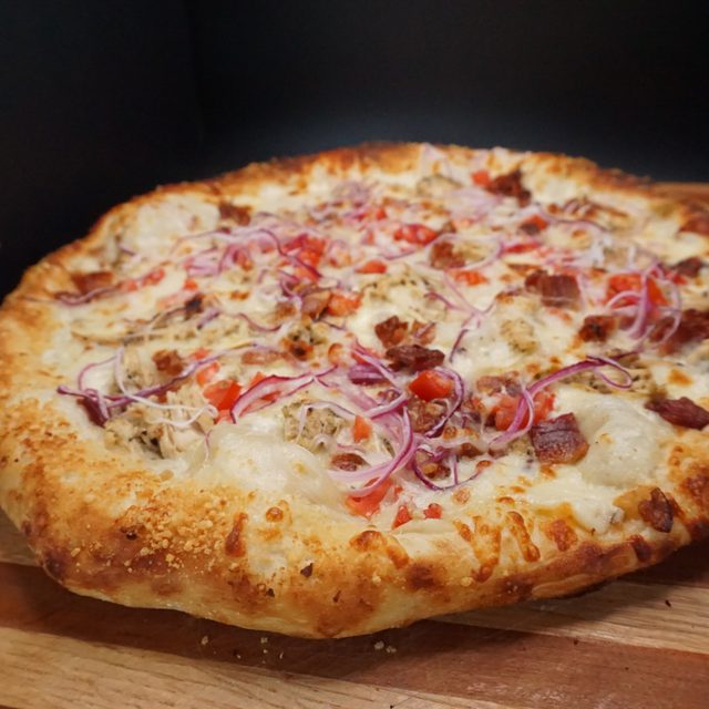 Buffalo chicken pizza with peppers and red onion